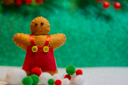Ginger cookie doll with snow balls on shimmering green color and Chirstmas ormament blackground. Selective focus.の写真素材