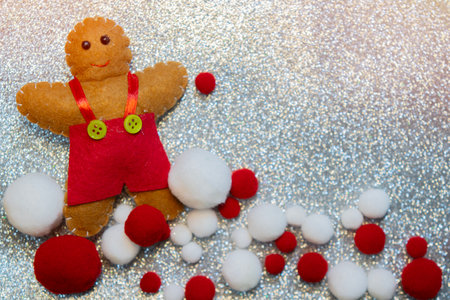 Silver glitter Christmas background with ginger cookie doll and decorations. Copy space.