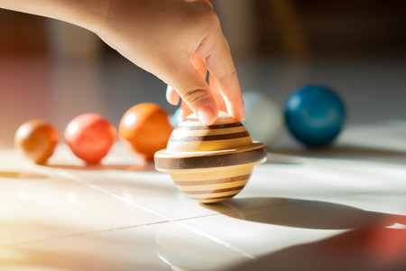 Hand of little boy playing a wooden model of the solar system at home. Concept: Science Day, games for kids, learningの写真素材