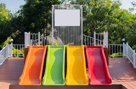 View of the colorful slide and the pool with blank banner above in nature resort. The concept of...