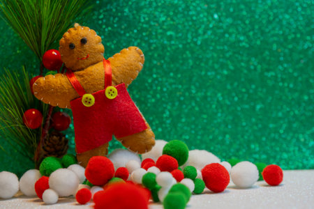 Gingerbread cookie doll and colorful snow over on green glitter background. Christmas New Year holiday concept.の写真素材