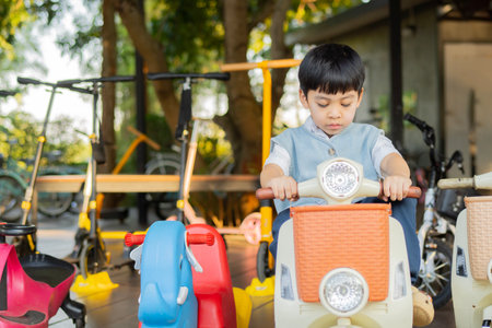 Asian Young boy on toy motorcycle in the Park, riding in the summer. the concept of summer holidays for childrenの写真素材