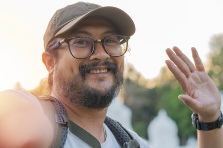 Handsome adult man taking selfie with smart mobile phone device outside. Close-up portrait concept.の写真素材