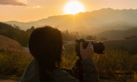 Side view close-up shot of tourist Asian woman with camera exploring on mountain in Thailand. Travel and vacation conceptの写真素材