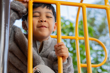 Kid exercise for health and sport concept. Happy Asian child boy playing at the playground. Happy kids face concept.の写真素材