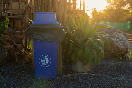 A clean and empty blue garbage bin in the park with sunlight. Space for text.の写真素材