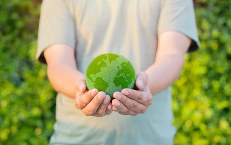 Human holding green plant globe model over nature background. Green World Environment ecology day, Life on earth. Selective focus.の写真素材