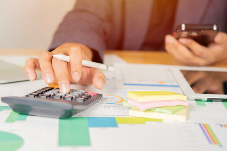 Business man or accountant working on calculator to calculate business data in modern office. Financial and tax systems conceptの写真素材