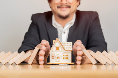 Human hand blocking wooden blocks, Represents protection and protection of safety, concept of insurance management planning. Property and Family Risk Reductionの写真素材