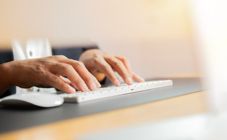 Desk, Computer keyboard and hands of man in office for typing email, administration and planning. Professional, corporate and worker on computer for online schedule.の写真素材