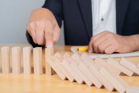 Business man placing wooden block on a tower concept risk control. Planning and strategy in business.の写真素材