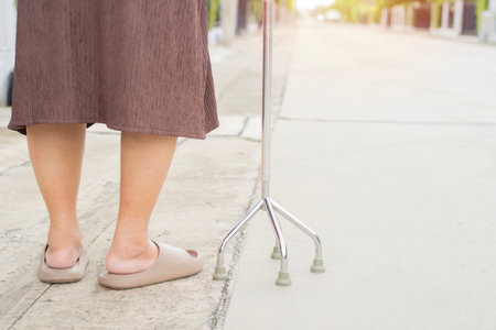 Cropped view of elderly woman standing with walker. Senior older woman using walker at outside. Retirement, health care conceptの写真素材