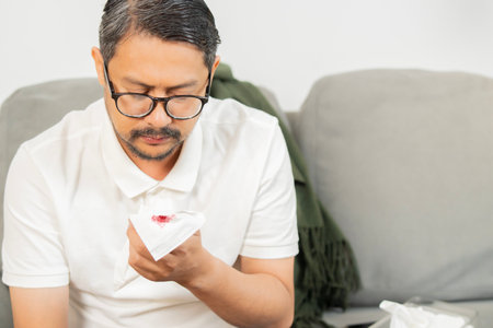 Mature ill male coughing up blood and sore throat causes of cough include pneumonia, bronchitis,...