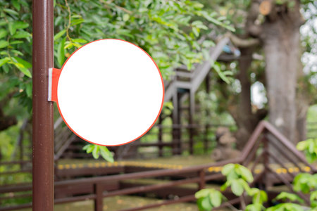 Rustic Wooden Circle Sign Hanging. Round sign on a steel pole in Lush Green Tropical Foliage. Copy space.の写真素材