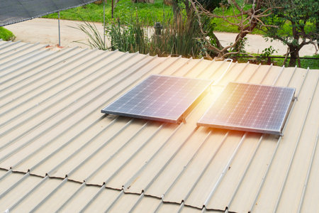 Mini solar panels installation on a roof of a storage building during sunny day in a rural resort. Sustainable energy from the nature conceptの写真素材