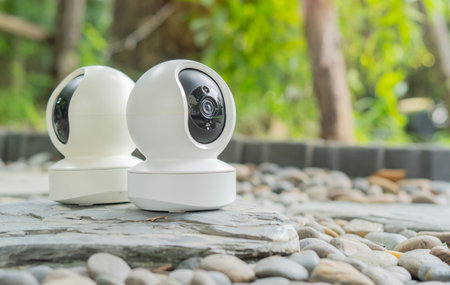 Photo of a two modern security camera on a rock floor in garden for home security and surveillance....