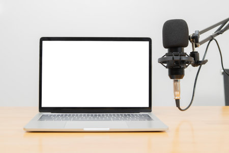 Studio Microphone Recording Podcast Audio nearby laptop with isolate screen on table. Copy space.