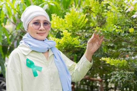 Portrait, senior and sick person relaxing in the park with strong mindset for courage to fight for health in retirement.の写真素材