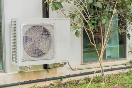 Dual inverter, combination of air conditioner compressor and heating pump, installed on a wall of family house.の写真素材