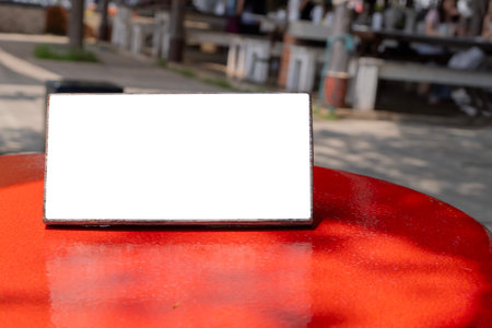 Empty sign on red rustic bar table at outdoor cafe. Empty space for advertising, marketing, informational messagesの写真素材