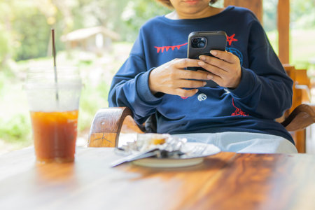 Cropped shot of woman typing a message on a smartphone device, replying to friends on a social...