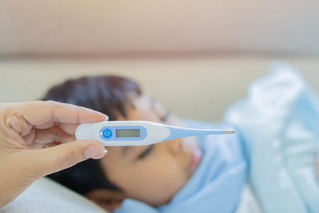 Little boy illness medicine flu fever and thermometer, Mom hand holding and check by the temperature of ill baby. Selective focus.の写真素材