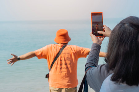 Tourist taking photo with smart phone over sea while during their travel summer trip. Selective focus.の写真素材