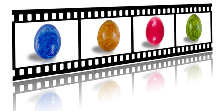 film strip with Easter eggs in different colors on a white background with reflectionの写真素材