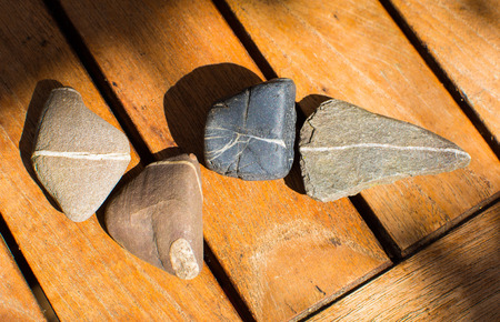 picture of four stones with stripes on timber deck