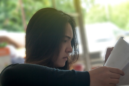 Side of the women with long hair reading a book.の写真素材