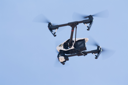 Udon Thani, Thailand, August 16, 2015: White drone, quadrocopter, with photo camera flying in the blue sky. Concept. Aircraft, remote unmanned aircraft.のeditorial素材