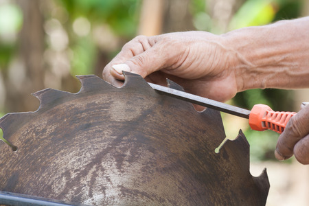Man hand holding a sharp blade, nail file, put on old, blur the background. Still Life Style.の写真素材