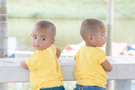 Baby twins stand Back together Look at the back.の写真素材