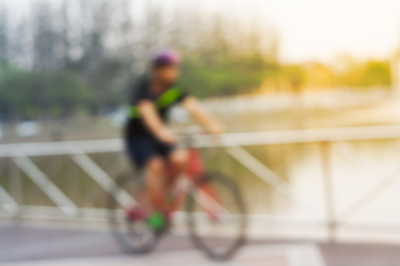The image is blurred. Young men were bicycling exercises on the waterfront.の写真素材