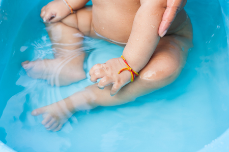 Infant seats soak in his bathtub.の写真素材