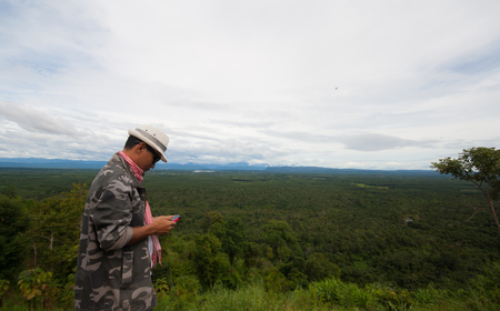 Thailand, Tourists stand on high are considered smart phones. Natural forest Background.の写真素材