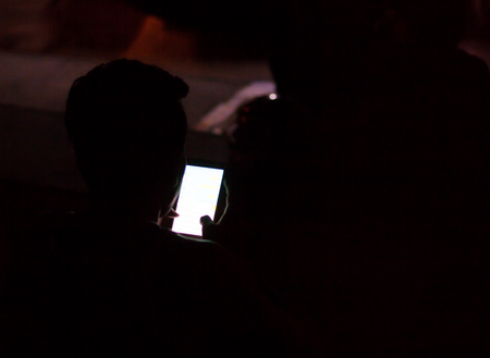 Men are using smartphones in the dark.の写真素材