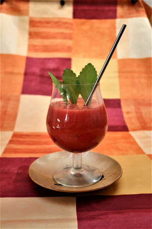 a cool glass of watermelon smoothie with a reusable drinking straw and three stevia leavesの写真素材