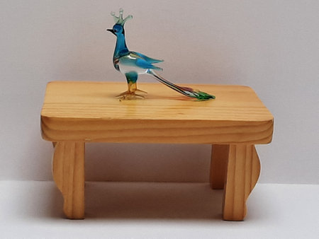 Decorative figure peacock in glass colorful on a small wooden tableの写真素材