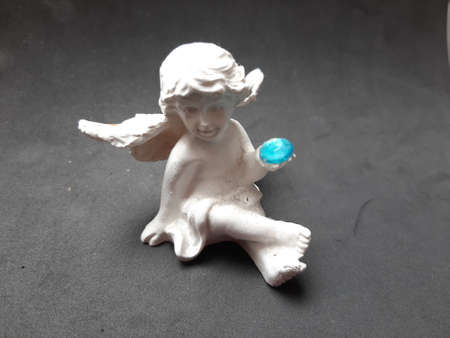 Decoration figure angel sitting white with blue ball in handの写真素材