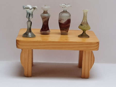 Decorative four small glass vases colorful on a small wooden tableの写真素材