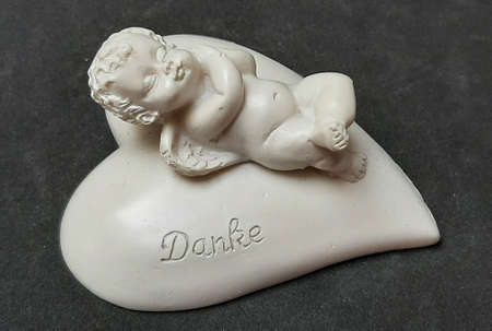 Decoration figure angel lying on heart with writing Thank youの写真素材