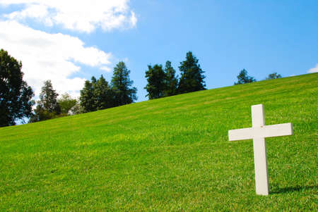 White Cross on a grassy field on a beautiful sunny dayの写真素材
