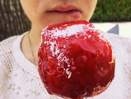 Woman with a red apple candyの写真素材