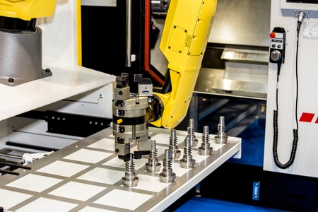Moscow, Russia - May, 2018: Fanuc M-20iA robot hand with Schunk gripper operating with CNC machineのeditorial素材