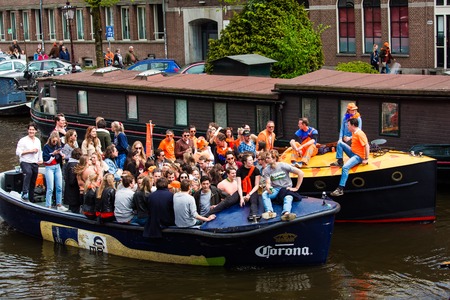 Amsterdam, Netherlands - April, 2018: People on the boat celebrate Kings day in Amsterdam city,...