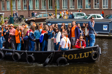Amsterdam, Netherlands - April, 2018: Boats on Amsterdam canals with people celebrate King's day in Netherlandsのeditorial素材
