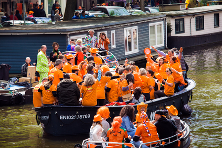 Amsterdam, Netherlands - April, 2018: Boats on Amsterdam canals with people celebrate King's day in Netherlandsのeditorial素材
