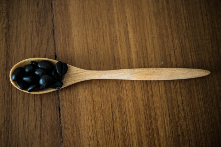 coffee beans in spoon on wood backgroundsの写真素材