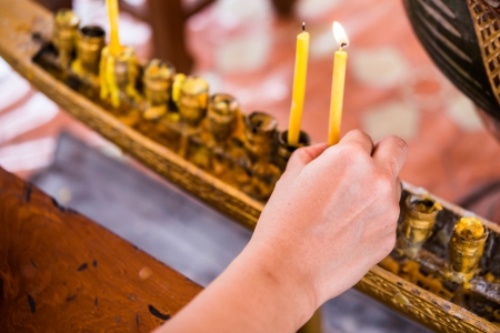 hand and candle in thai templeの写真素材